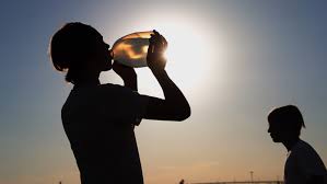 People drinking water amidst extreme heat is shown