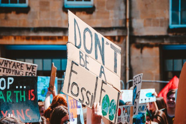 Protesters holding climate change signs outdoors.