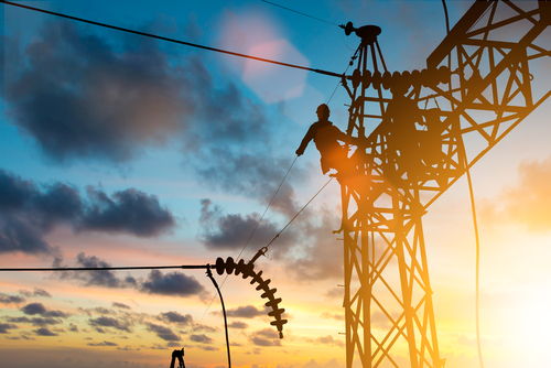 Man is working on an Electrical Transmission line