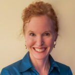 Portrait of smiling redheaded woman in blue blouse