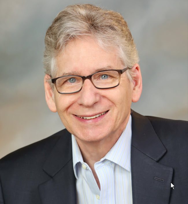 Smiling older man wearing glasses and suit